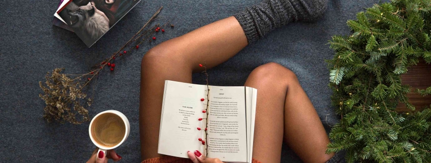 Frau sitzt gemütlich am Boden - wir zeigen Dir, wie Dein Weihnachten weihnachtlicher werden kann.