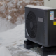 Eine Wärmepumpe im Winter mit Schnee.