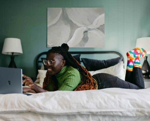 Entspannte Person liegt auf dem Bett – sorgt mit dem Wechseln zum Ökostromanbieter MAXENERGY für grüne Energie und mehr Gelassenheit im Alltag.